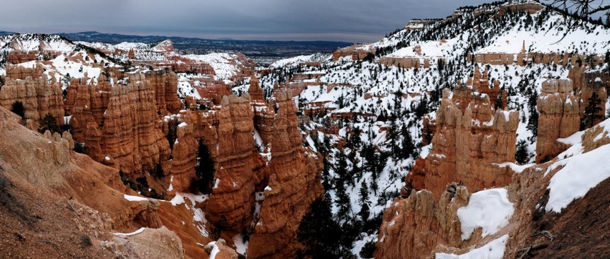 西南美丽犹他州满是棕色岩石和积雪的冬季寒日中布赖斯峡谷全景图片