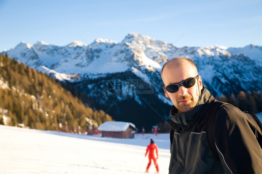 冷冻阿尔卑斯山冬季运动系列中的青年男子岩石成功图片