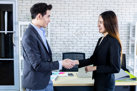 公司男人白种亚洲女商和在签署合同或握手问候交易后在办公室背景中与亚洲女商人和握手企业表示信心大有雄而且成双对以及背景图片