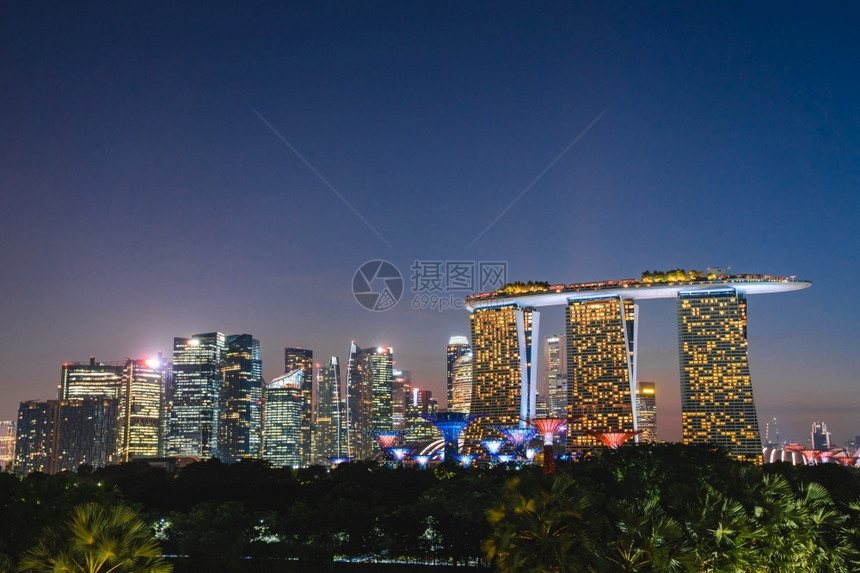 大约新加坡海滨沙滩周围商业建筑的风景新加坡天际夜间观视黄昏时分Marina湾的商业海区雕塑摩天大楼图片