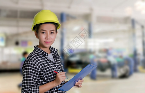 亚洲女工程师和技机械正在检查和汽车修理厂一辆板上的名单妇女维修员和技工具女店铺背景图片