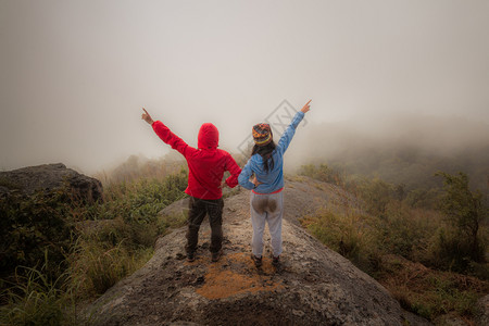 悬崖快乐的远足夫妇来到山顶上徒步旅行朋友们自由高清图片素材