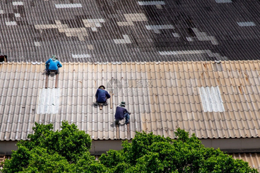 团队外部泰国曼谷20年6月13日三家修理被破坏的工厂屋顶上瓷砖的杂工合作伙伴图片
