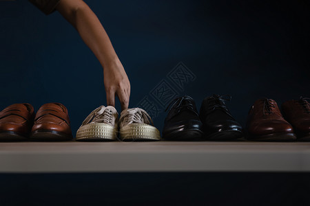 优雅男子穿鞋时的装男挑一件短鞋穿衣去不工作或平衡放松概念皮革时尚图片