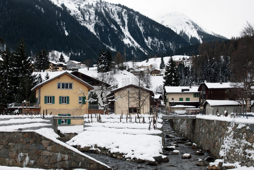 靠近场景爬坡道瑞士Klosters附近邻山流的房屋位于瑞士克洛斯特图片