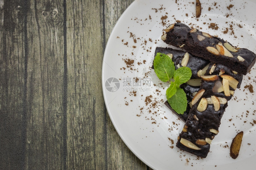 富有的白色板块和木本背景上的坚果和薄荷蛋糕巧克力面包饼顶部视图焦点复制空间棕色的对待图片