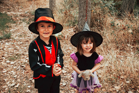 假期戏服两个孩子在树林里伪装成万圣节帽子图片
