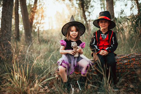 两个孩子在树林里伪装成万圣节戏服骨骼图片