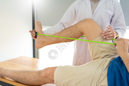 帮病人进行腿部康复治疗的医生图片