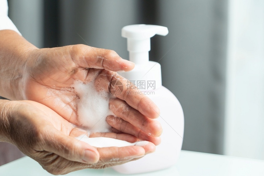 Covid19Corona手清洗概念高级手施用酒精凝胶或抗细菌肥皂以清洁和除细菌和液体消毒按图片