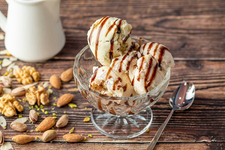 盘子最佳杏仁冰淇淋和核桃花兰冰淇淋在玻璃碗里加焦糖酱美食图片