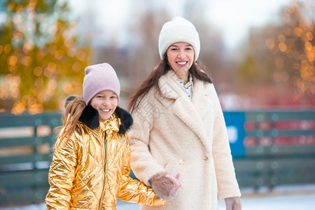 可爱的小女孩和妈在溜冰场滑冰图片