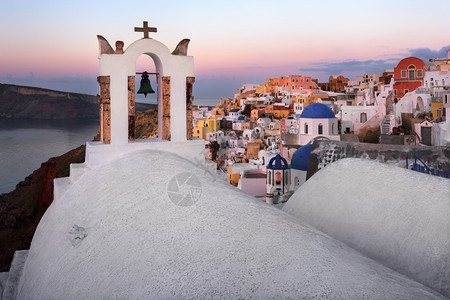 锡拉黎明上午在希腊圣托里尼的奥亚村白城市的图片