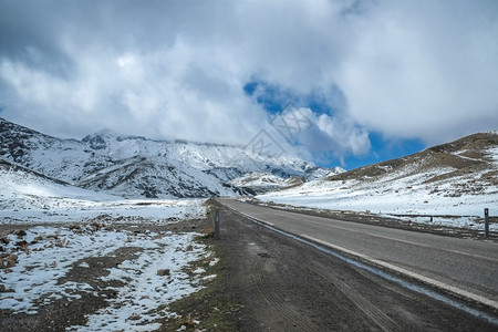 包围在摩洛哥高集山脉中一条由雪盖山峰环绕的公路范围高速图片
