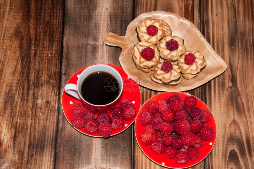 旧木制桌子顶端的红莓和咖啡杯质地早餐饮料图片