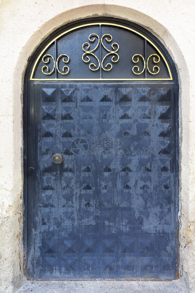 墙古老的旧铁门有石拱金属板和铁制锁古老的旧门用伪造的手柄和上边木板实优质图片