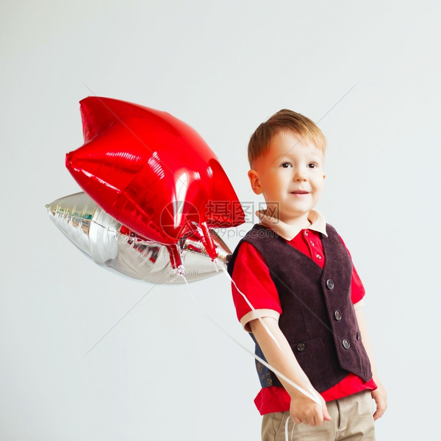 童年婴儿带着恒星形气球的小男孩快乐子在白色背景下玩着多彩亮闪发光的浮壳气球丰富多彩的图片