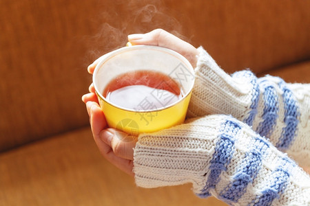 乐趣淑女衣服握着茶杯黄色的热与冬天相伴而来的妇女手图片