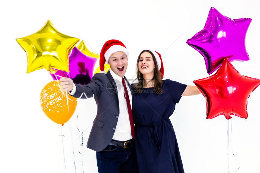肖像家庭情人节20年新快乐概念夫妇工作年龄一套男士西装手持20年标签和彩色气球与幸福面孔庆祝白色背景的新派对圣诞节期间图片