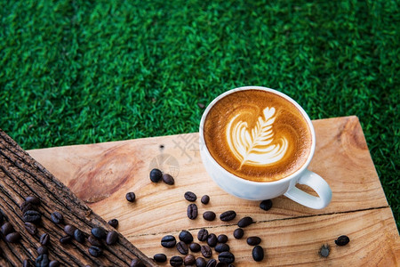 牛奶卡布奇诺咖啡和豆在木材纹理背景早晨或咖啡时间餐品尝富有的图片
