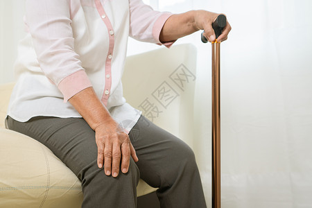 手持拐杖膝盖疼痛的老年人图片