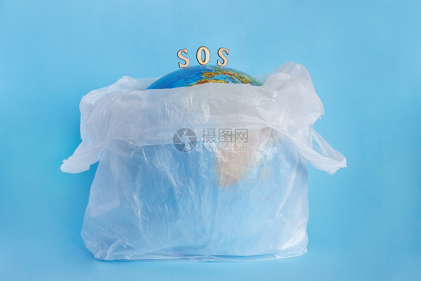 题词危险以塑料袋和刻有SOS蓝色背景概念生态与塑料纤维素乙烯聚地球日有关的污染世界环境日a将地球纳入塑料袋中的地球伤害图片