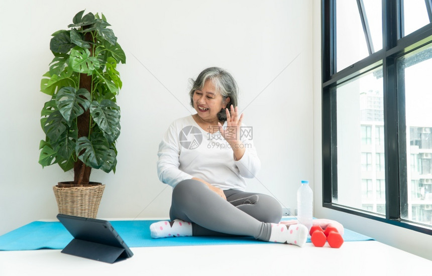 身体的上笔记本电脑在线课程的亚洲老年妇女在家中起居室练习时观看膝上型计算机在线课程网上锻炼培训概念合身成熟图片