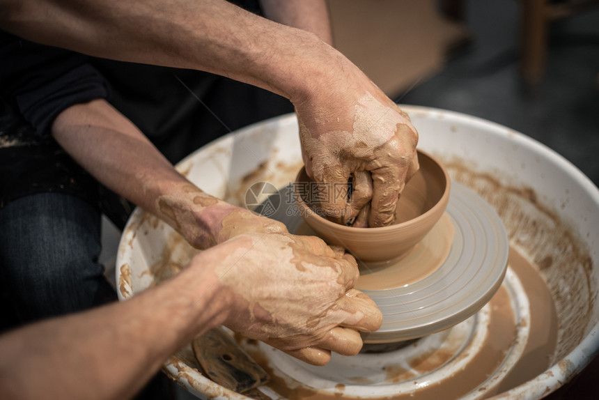 勤杂工教学水壶专家陶器匠教一个人在陶器轮上工作近身脏手图片