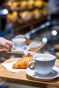 桌子早餐休息室咖啡和羊角面包在柜台的托盘里用着模糊的糕点店背景图片