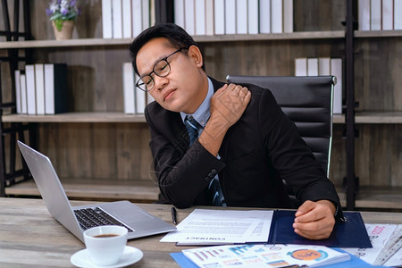 电子的概念痛苦实业家在办公室治疗护理概念中工作时的肩部疼痛图片