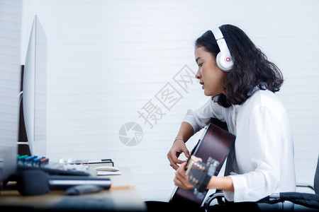 青年就需敢发声生产人们唱歌专业音乐家亚洲女青年发声员佩戴耳机弹吉他在家庭数字工作室录音一首歌乐制作技术概念笑声背景