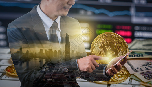商人使用移动电话与Bitcoin交换易屏幕在各国纸面银行加密货币和投资概念的ClothupBitcoins模型上用移动电话与Bi背景图片
