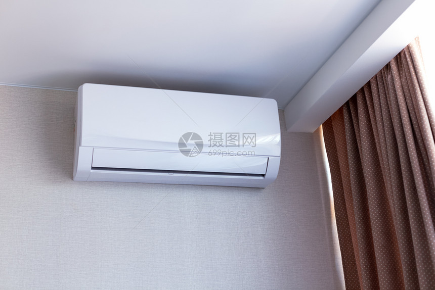 在公寓内房间的墙壁上安装小型空调以平静的米色调关闭了内政部调理健康状况白色的图片