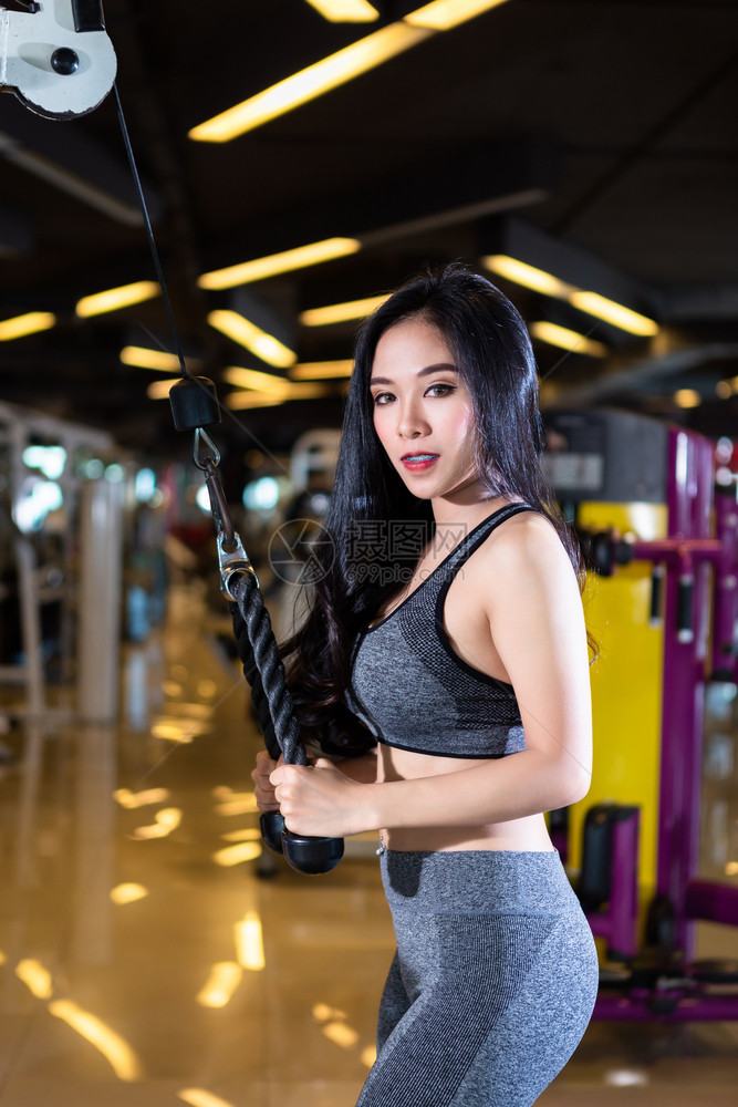 亚洲女在体育健身室内和康俱乐部中以运动设备Gym背景体操训练用划线机座位有电缆机器进行锻练训的亚裔妇女运动服排健美图片