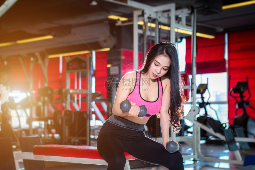 锻炼成人室内的亚洲女在体育健身室内运动和俱乐部中进行有哑铃运动的锻练训并配有运动设备体操背景的健身俱乐部亚裔妇女图片