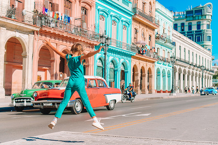 大街上女孩殖民建造在古老哈瓦那的美国经典汽车中街上的美貌女孩与古老的美国经典汽车在街上搭配着可爱的女孩古巴旅游女客在哈瓦那流行地区颜色背景