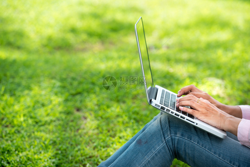 在公共园户外工作在笔记本电脑室外工作对坐在公园里做笔记本的女进行笔记本工作的图像剪裁成会议数字的工作场所图片