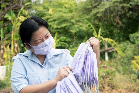 室外手拿防护口罩的女性图片