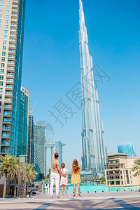 浪漫的城市父亲和孩子家庭在迪拜背景中有摩天大楼从后面的快乐家庭走在迪拜与布吉哈利法摩天大楼在背景中背景图片