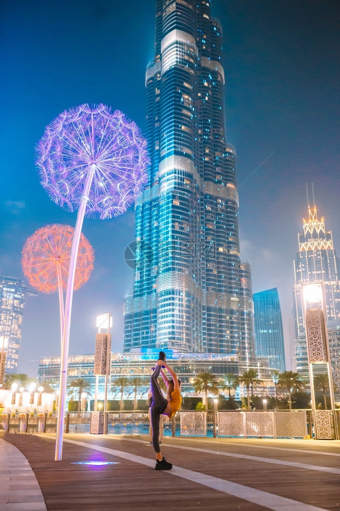 假期阿拉伯联合酋长国迪拜20年月日晚上在迪拜度假的可爱小女孩在迪拜节假日快乐女孩走在迪拜背景是摩天大楼旅游建造图片