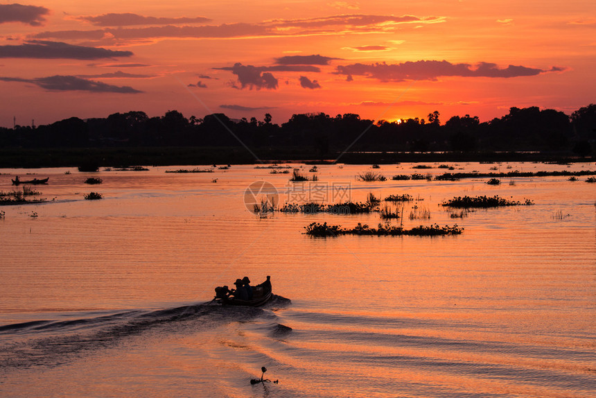 抓住场景轮廓在缅甸曼德勒日落时渔民在湖上驾驶一艘渔船的休长轮图片