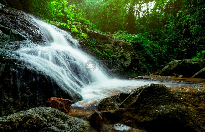 叶子雨林级联热带森的瀑布与绿树和阳光相伴瀑布在丛林自然背景中流淌岩石或瀑布中的头长距离摄影长距离照射摄影师图片