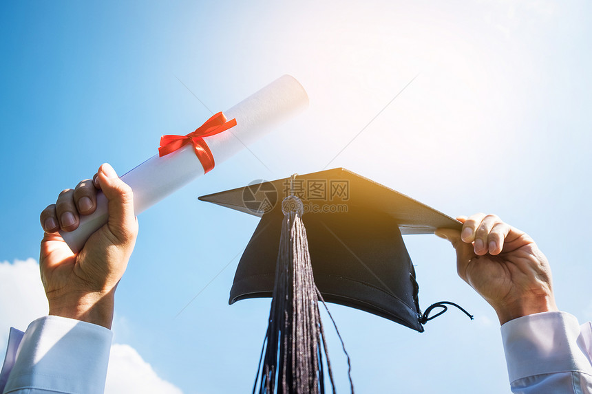 毕业生举起证书和学士帽的照片图片