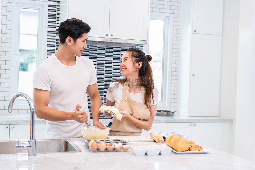 在室内亚洲夫妇一起在厨房做饭和烘烤蛋糕男人和女在家庭爱与幸福概念上互相期待蜜月和情人节主题是甜蜜的月和情人节主题厨师脸图片