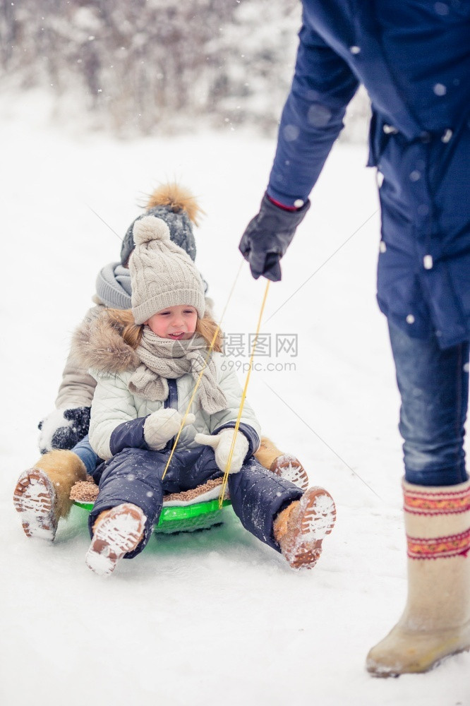 小女孩喜欢乘坐雪橇孩子们拉在户外玩雪手套爸帽子图片