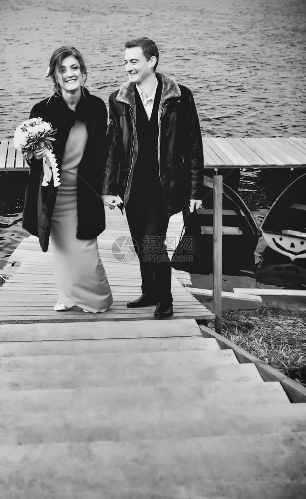 船筛选快乐的情侣在桥上手牵站立与模糊的湖泊对抗选择焦点黑白古老胶片过滤器在单色中快乐的情侣图片