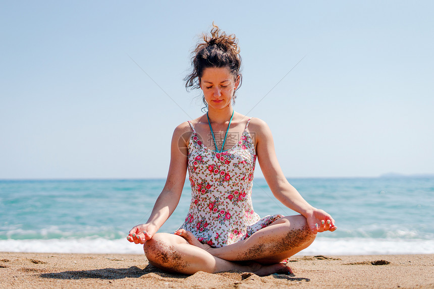 练习夏服女青年在海边滩或做瑜伽冥想在阳光明媚的白天拉伸冥想放松莲花的位置海滨锻炼图片