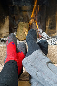 壁炉两只徒步者的脚在冬天长途跋涉之后被火烧热起来温暖的黄色灰高清图片素材