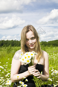 活动在草地上鲜花的年轻女子愉快植物成人高清图片素材