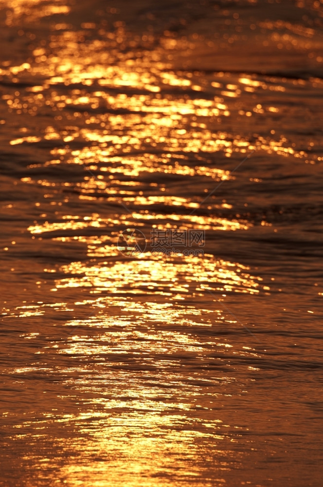 明亮的太阳升起横跨印度海洋和水闪亮的金子射线天空图片